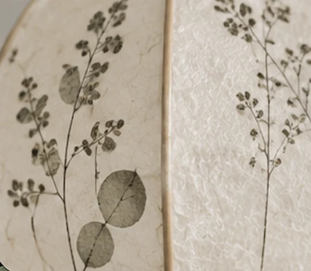 Feuilles et petites fleurs visibles dans la texture du papier