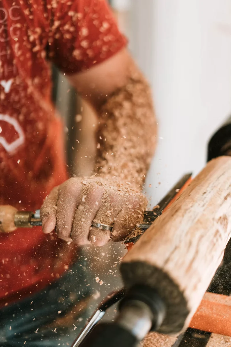 Le geste d’un artisan travaillant le bois au tour
